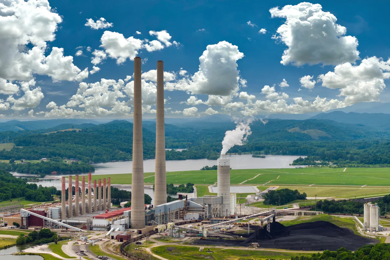 An aerial view of a factory emitting smog from a smoke stack representing toxic exposure and environmental hazard claims handled by Trident Law HQ
