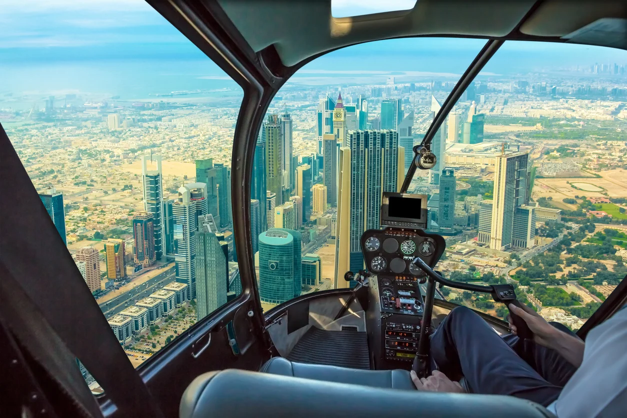 Trident Law HQ fights for people harmed in helicopter crashes, depicted by this view from inside the helicopter cockpit overlooking the downtown area of a large city 