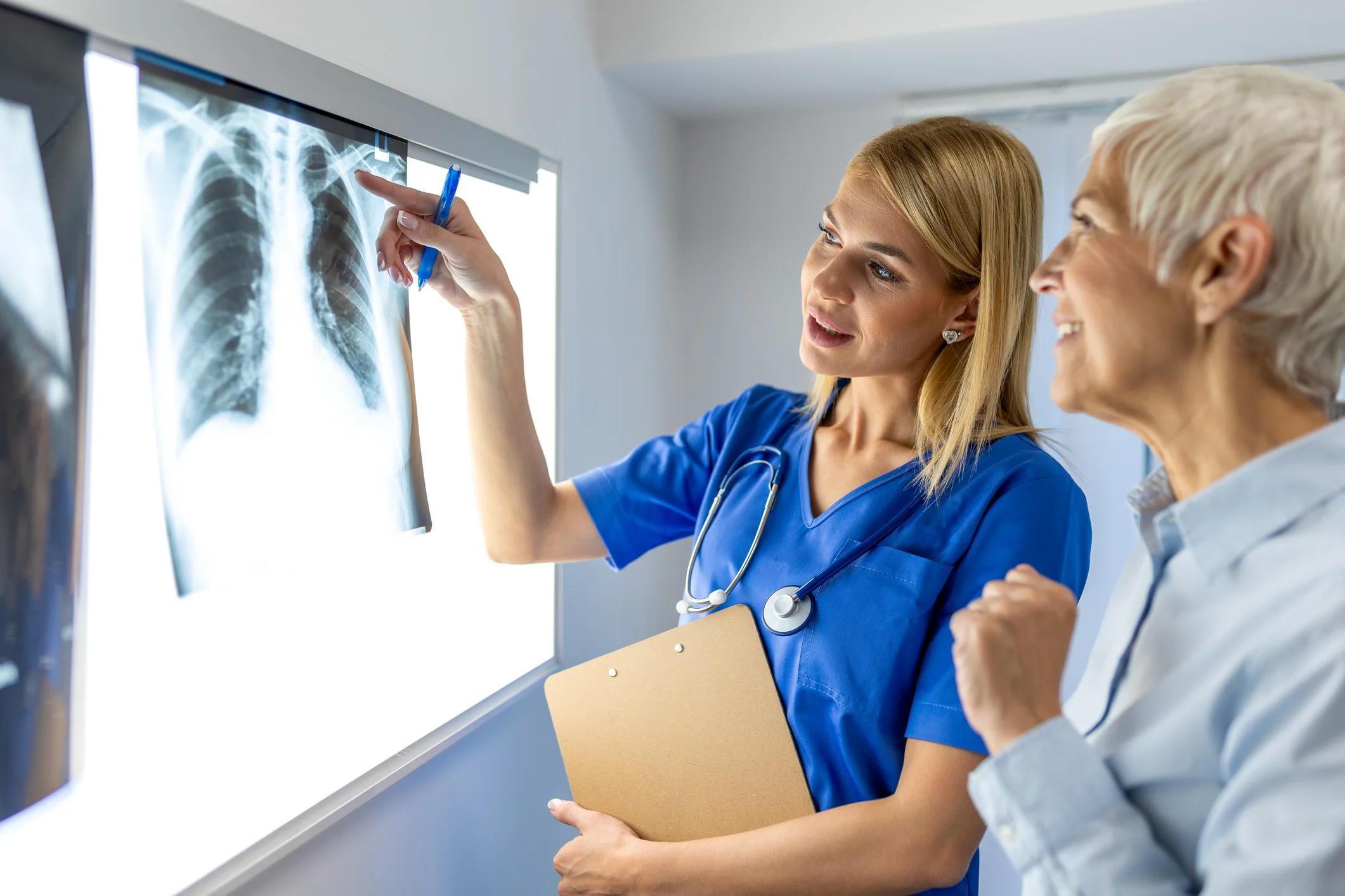 Trident Law HQ fights for clients facing lung cancer harm caused by negligence, represented by a female doctor in blue scrubs pointing out a lung x-ray image to a patient 