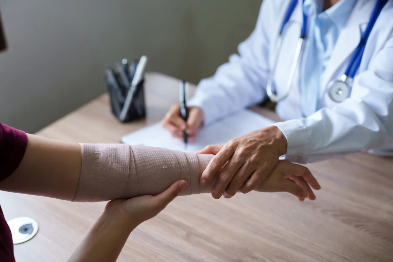 An image of a medical doctor examining a patient with a personal injury and signing paperwork to underline personal injury claims from Trident Law HQ