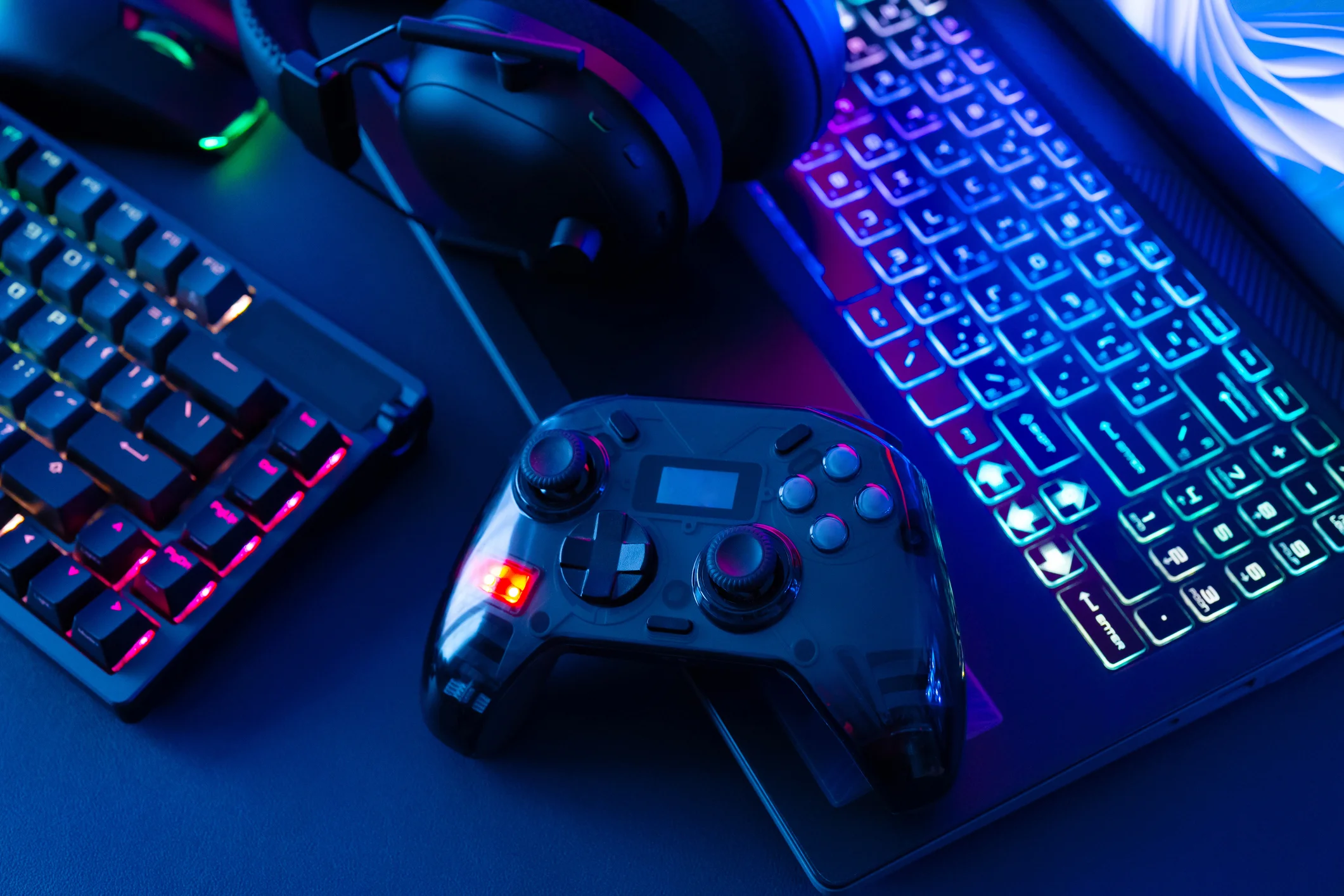 An over shot view of a game controller, keyword, and gaming headphones conveying excessive gaming behavior and video game addiction cases handled at Trident Law HQ