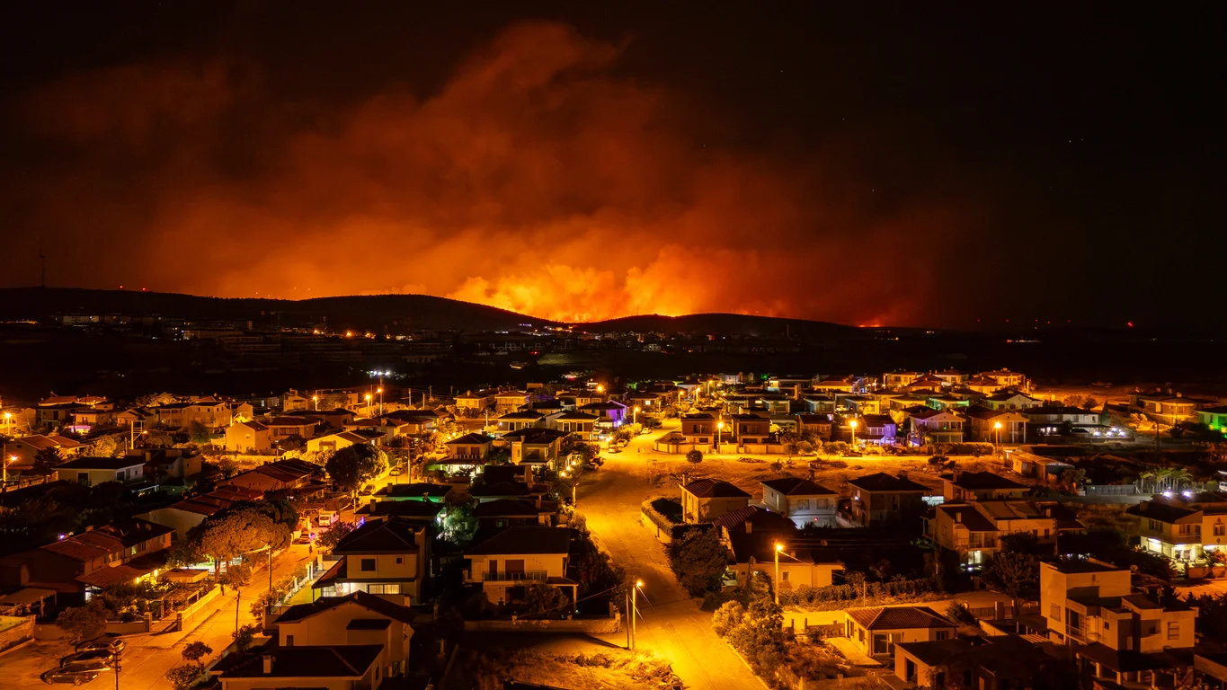 An aerial view of an out-of-control wildfire ravaging a large city representing destructive wildfire events and wildfire-related legal claims handled by Trident Law HQ
