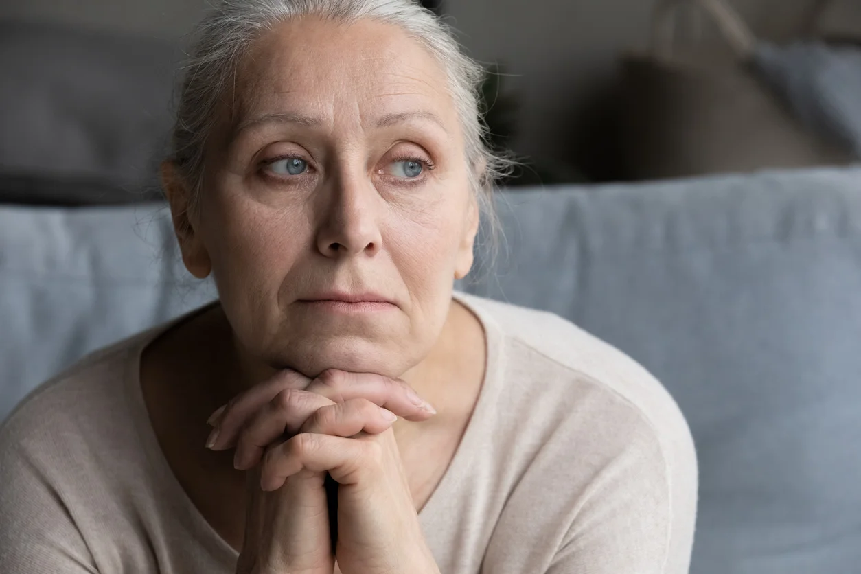 Elderly woman appearing concerned, representing the emotional impact of caregiver neglect.