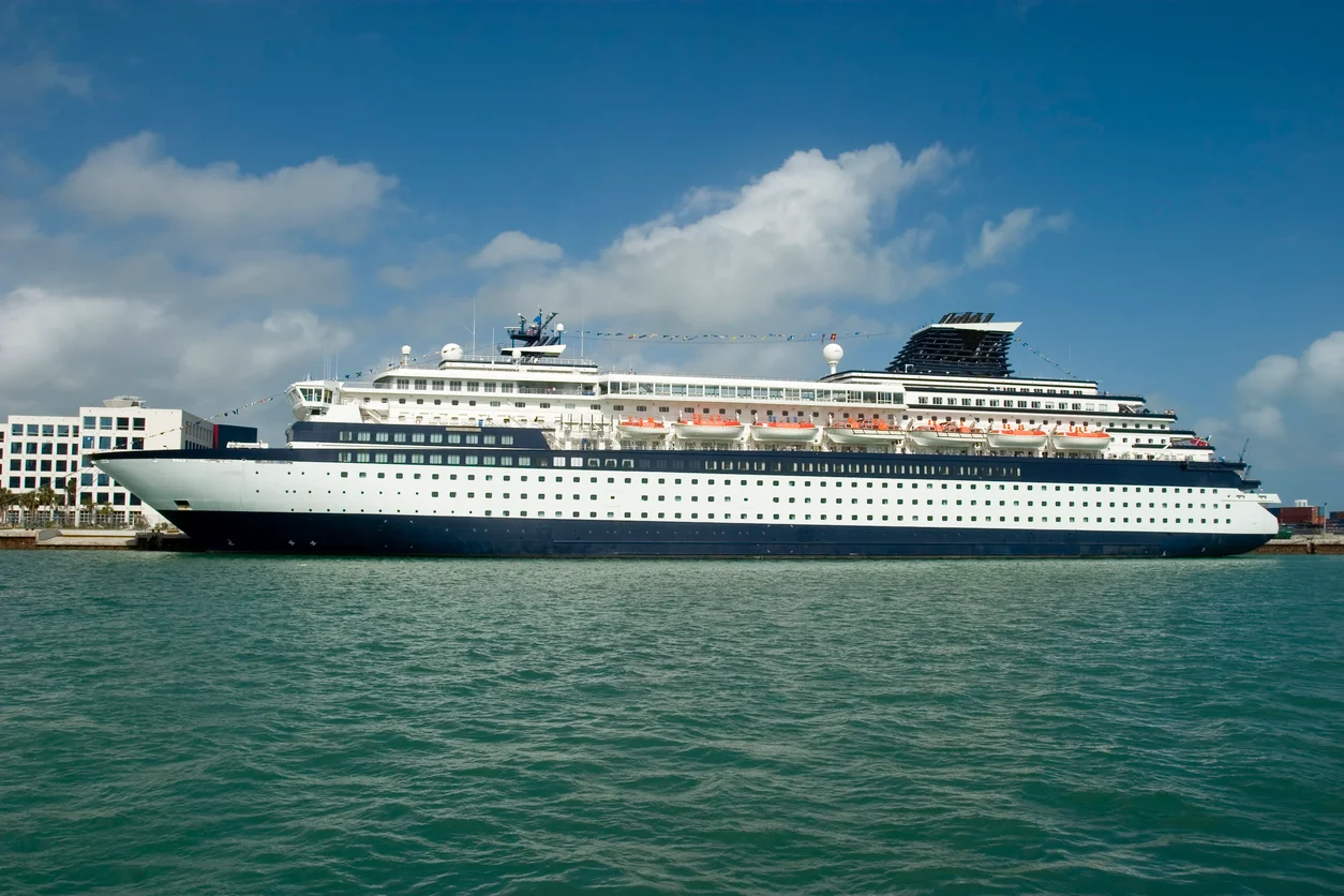 A view of a large commercial cruise ship traveling across the water illustrating injuries and hazards aboard cruise ships investigated by Trident Law HQ
