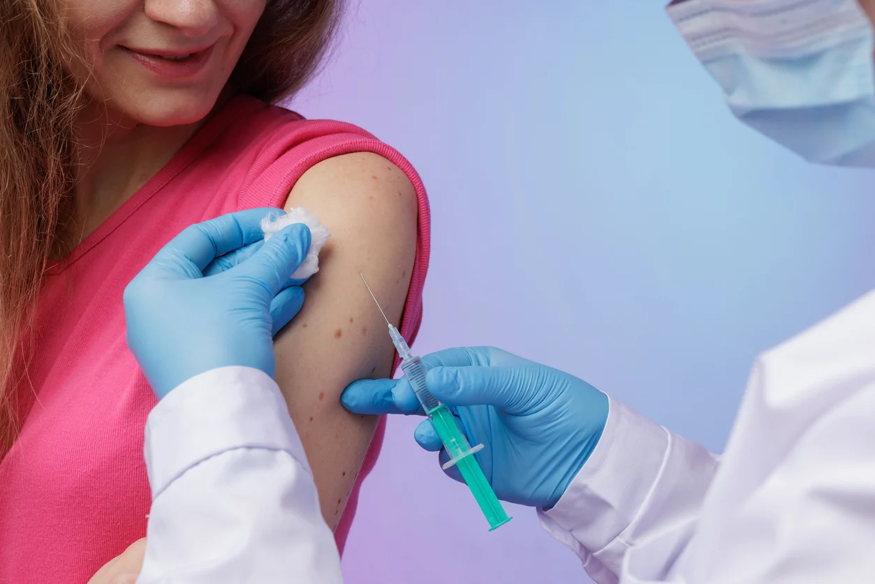 An image of a woman receiving a shot in the arm from a doctor wearing medical gloves symbolizing harmful side effects and Depo-Provera injury claims handled at Trident Law HQ