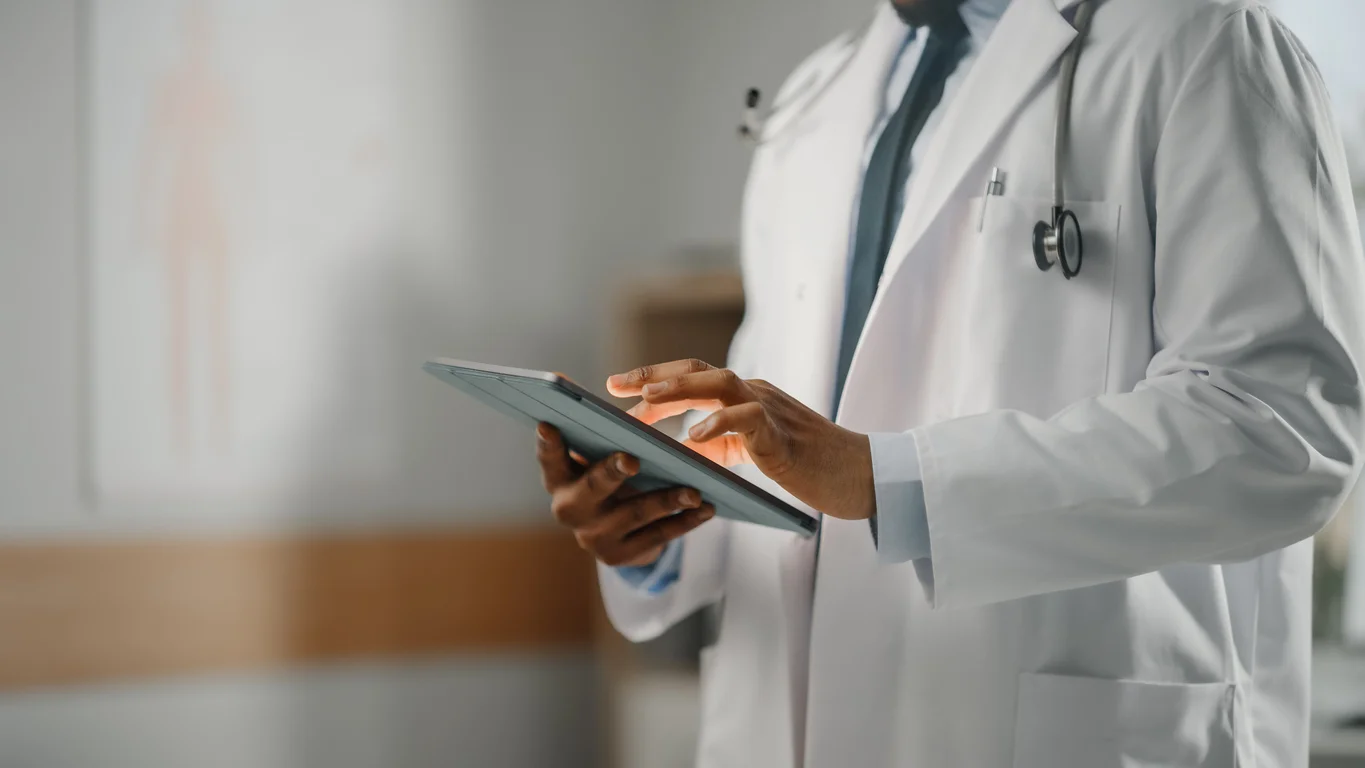 A photo of a doctor in a white coat looking down at medical notes symbolizing preventable medical errors and malpractice cases litigated by Trident Law HQ