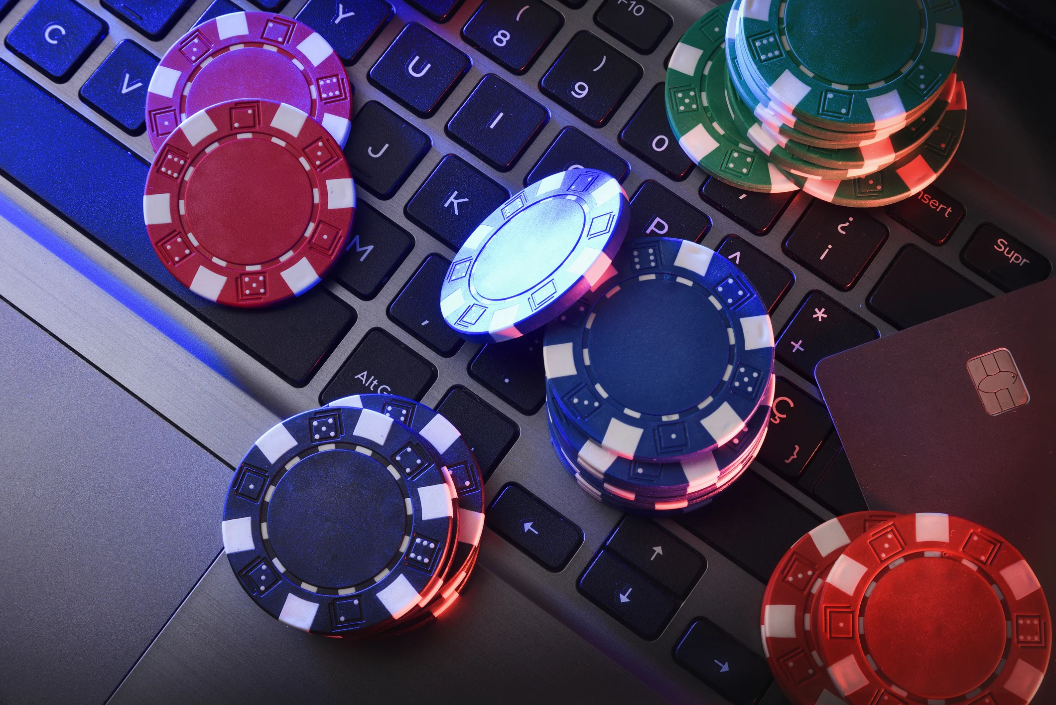 Trident Law HQ provides legal help to people harmed by online gambling, as shown by a group of red, blue, and green poker chips being thrown on a keyboard