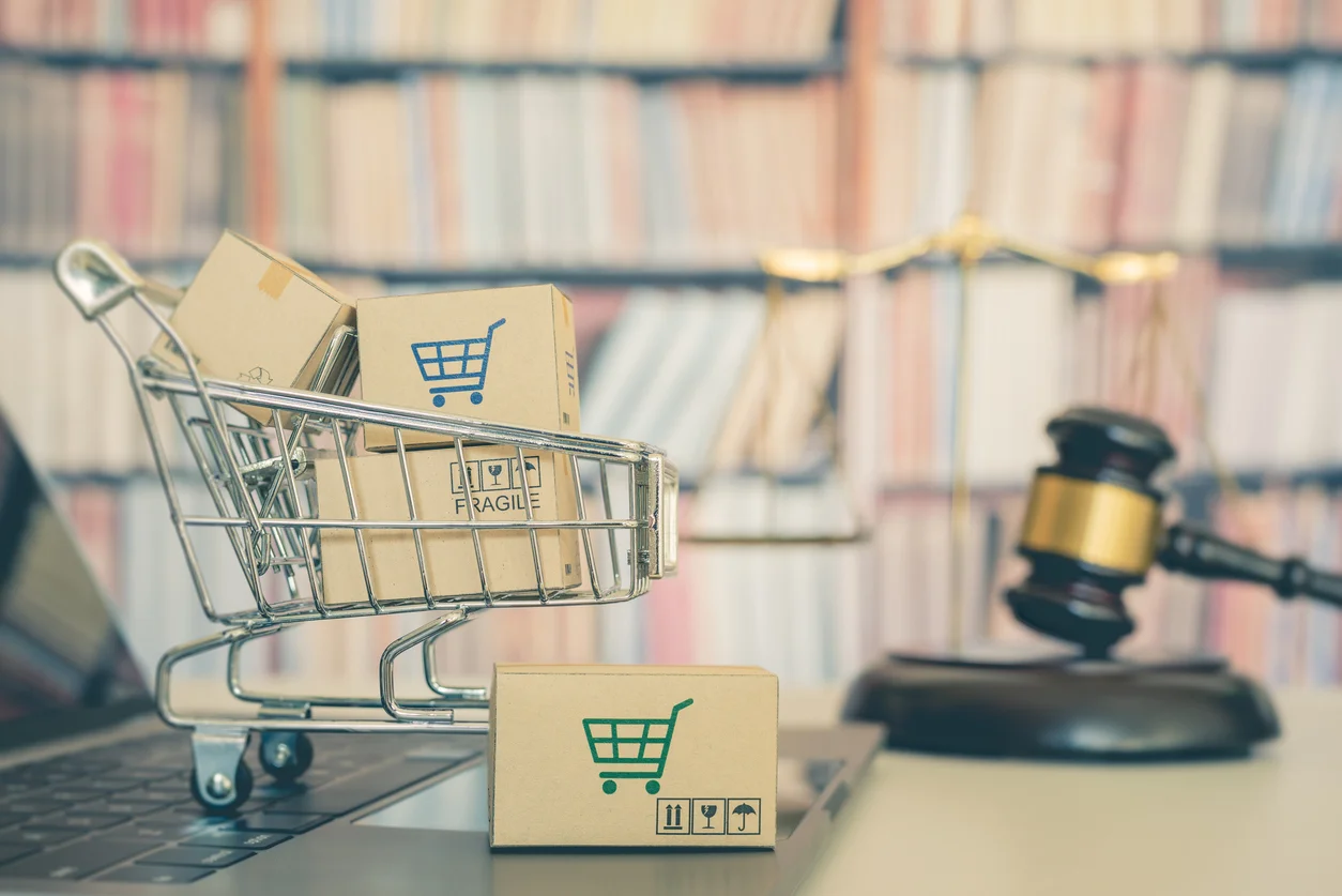 An image of a miniature grocery basket stuffed with small brown boxes, each with grocery cart symbols next to a gavel illustrating the product liability cases our attorneys at Trident Law HQ handle 