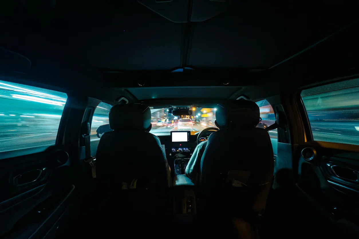 Rideshare-related sexual abuse cases are handled aggressively by Trident Law HQ, shown through this image of a backseat point of view of a dark rideshare in shadow 