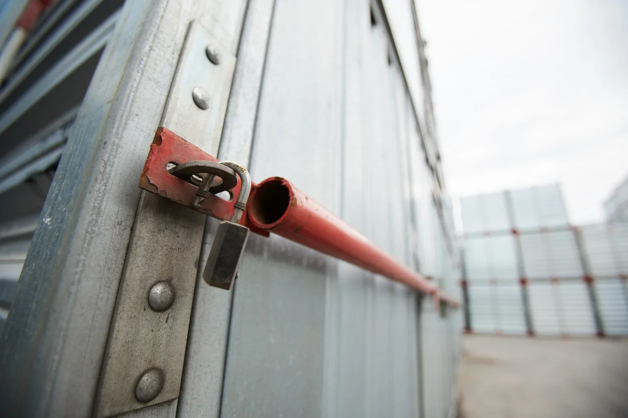 Close-up of sealed metal shipping container, hanging open lock after burglary, symbolizing theft claims handled by Trident Law HQ