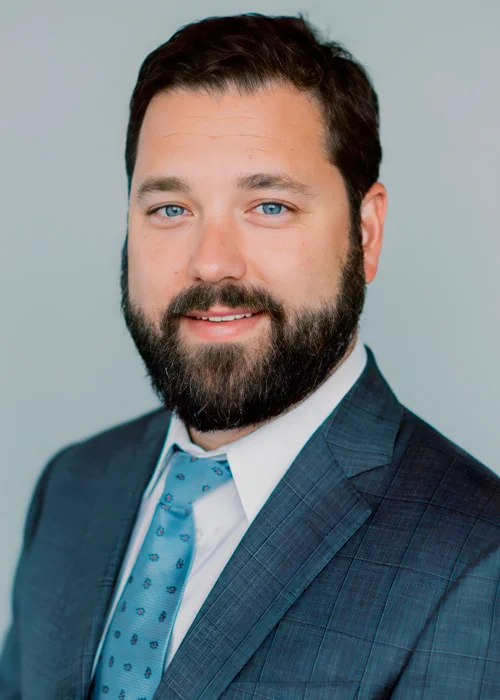 Polished professional portrait of Todd Buchanan, attorney and co-counsel at Trident Law HQ, captured against a solid color background.
